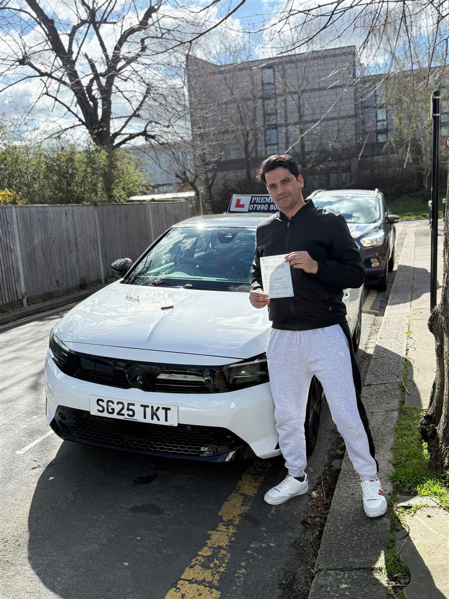 Learner celebrating a first-time driving test pass with his certificate