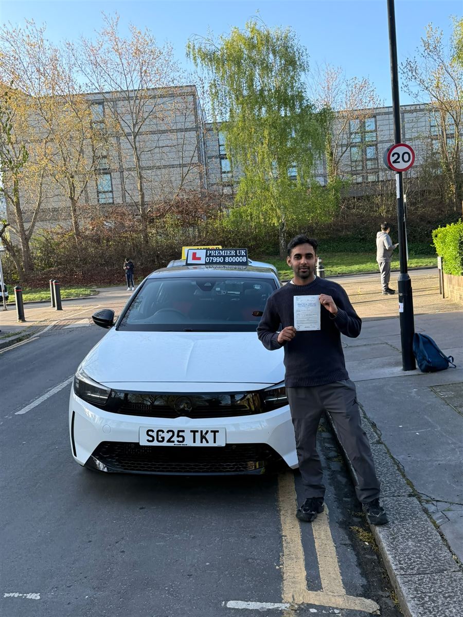 Learner celebrating his driving test pass on a South London high street