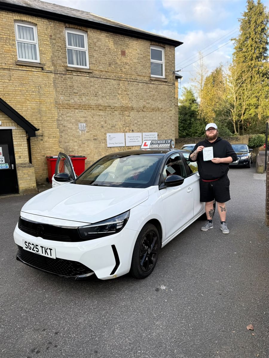 A Vision Driving School learner holding his pass certificate outside the driving test centre