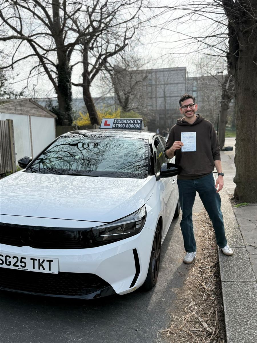Learner celebrating his driving test pass with his certificate in hand